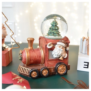 Detail of red vintage Christmas train snow globe with Santa Claus and festive bokeh lights