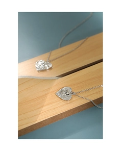 Detail shot of heart-shaped angel relief pendant on a fine silver link chain necklace