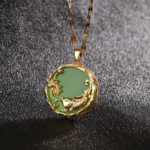 Minimalist gold plated titanium necklace featuring a green shell flower and fish pendant