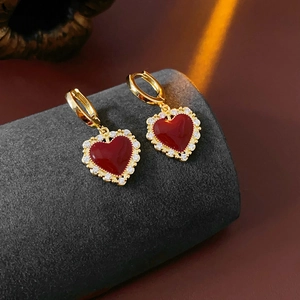 Dettaglio orecchini a cuore rosso scuro placcati oro con zirconi e finitura smalto