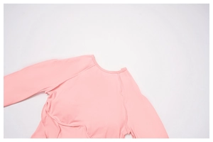 Close-up of pink long sleeve yoga top featuring curve stitching and stretch fabric