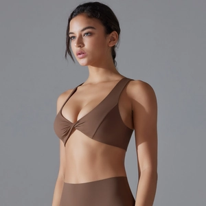 Detail of mocha brown sports bra with deep V-neck and twist-front design on stretch fabric
