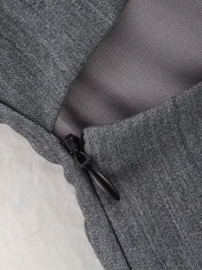 Détail du zip invisible et de la texture du tissu mélangé sur ce haut cintré gris