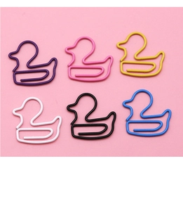 Close-up of duck-shaped colorful coated metal paper clips on pink background