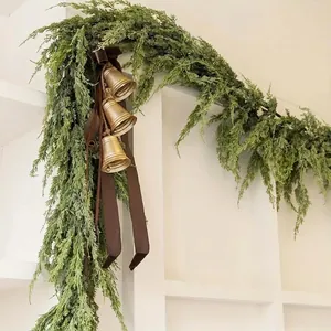 Evergreen cedar Christmas swag with bronze bells and dark brown velvet bow for home decor