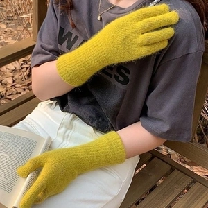 Detailed knit texture and ribbed cuff on warm yellow winter gloves for outdoors