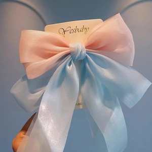 Detail of oversized pink and blue tulle ribbon hair clip with delicate sheer layers