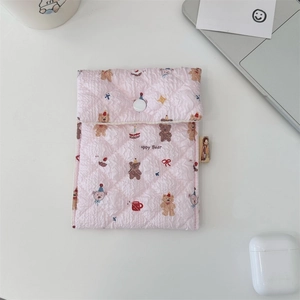 Detail view of pink quilted fabric sanitary pouch with cute cartoon bear pattern