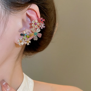 Close-up of elegant flower ear cuff with colorful crystals worn on a model's ear