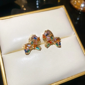 Macro detail of gold plated pony earrings with colorful zircon stones in a gift box