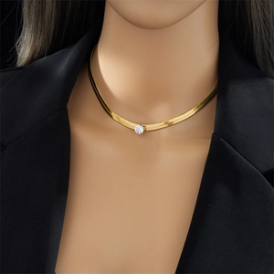 Minimalist gold snake chain necklace with a round crystal pendant worn by a model