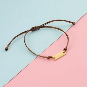 Adjustable brown braided bracelet with a polished gold stainless steel bar detail