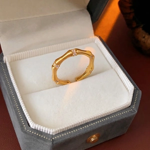 Golden bamboo joint open ring with white zircon accents in a velvet jewelry box