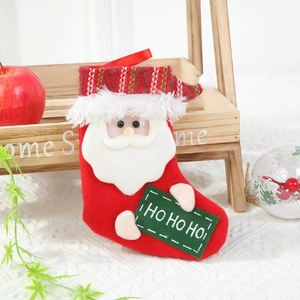 Detail of red Christmas stocking with 3D Santa Claus and HO HO HO sign in festive setting