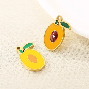 Detail showing enamel fruit pendants in mango shape with polished gold metal edges