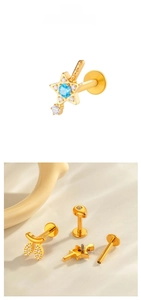 Detailed view of titanium gold piercing set with star and leaf designs and blue zircon stones