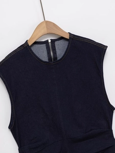 Detail showing the round neckline and back metal zipper of the navy denim dress