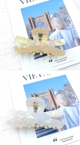 Detail of cross-shaped hair claws in cream and pearl white with marble texture