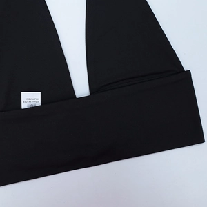 Détail de l'étiquette de lavage noire taille S montrant 83% polyester et 17% élasthanne
