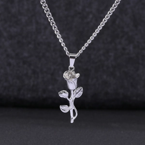 Macro detail of silver stainless steel 3D rose pendant and delicate chain necklace
