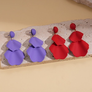 Pair of purple and red double-layered matte petal earrings on a stone slab background