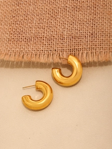 Detalle de pendientes de aro en C dorados gruesos con acabado pulido chapado en oro 18K