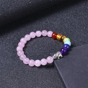 Pink rose quartz chakra bead bracelet with silver elephant pendant on dark stand