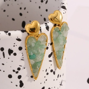 Detailed close-up of 18K gold plated heart earrings with green crushed stone on a ceramic cup