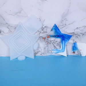 Detail view of star and square resin molds with glossy gold foil craft ornaments