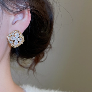Close-up of model wearing gold-plated square floral zircon earrings with pear-shaped stones