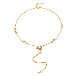 Détail macro d'un collier pendentif étoile dorée avec cristaux et perles claires