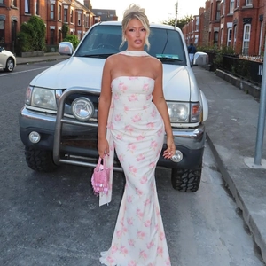 Detailed back view of a slim floral dress with pink roses and a matching neck ribbon