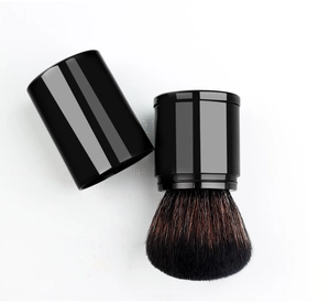 Detail of retractable makeup brush with soft bristles and protective black cap