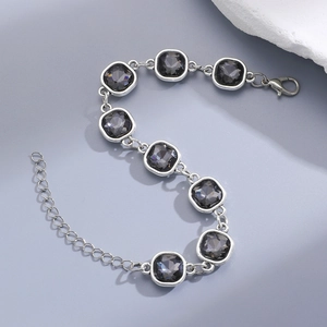 Close-up of silver chain bracelet with square black crystals and lobster clasp detail