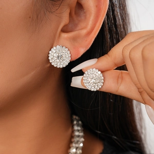 Close-up of a silver-tone cluster stud earring with sparkling cubic zirconia on an ear