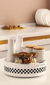 Close-up of a rotating kitchen spice rack with ceramic jars and wooden lids on a base