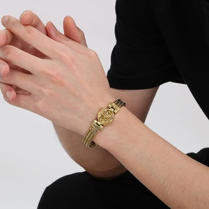 Detail of men's vintage dragon head bone link bracelet in gold finish on wrist