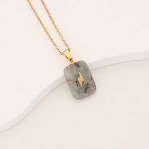 Gold chain necklace featuring a rectangular grey stone pendant with a lightning bolt inlay