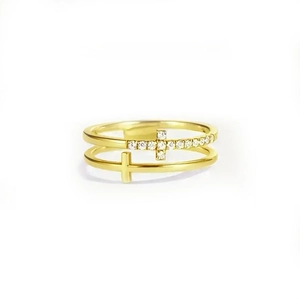Close-up of double-layer gold ring with a sparkling cross and minimalist metallic band