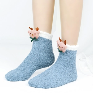 Detail von plüschigen blauen Korallenvlies-Socken mit 3D-Rentierpuppe und weißem Flaumrand