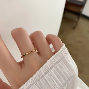 Close-up of 18k gold plated ring with rainbow cubic zirconia worn on a finger