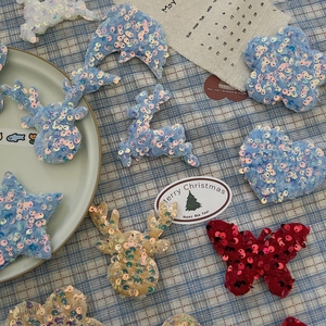 Flat lay of shiny sequined Christmas fabric ornaments in deer and star shapes