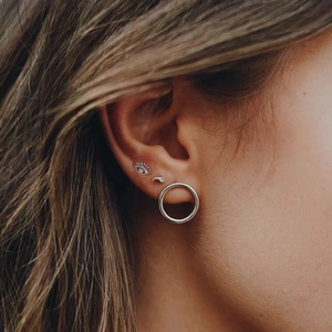 S925 sterling silver eye stud earrings set with crystal accents and pearls worn by a model