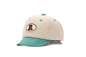 Vue détaillée d'une casquette de baseball pour bébé beige et verte avec patch lettre R