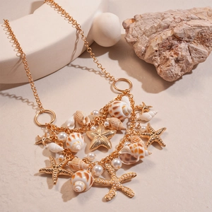Detailed close-up of a layered gold necklace featuring starfish, seashell, and pearl charms