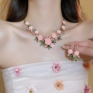 Detail of pink rose and pearl necklace with sparkling rhinestones worn by a model