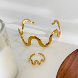 Golden wavy textured jewelry set featuring an irregular open bracelet and matching ring