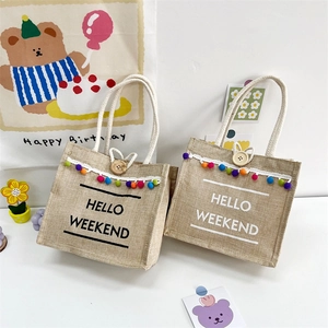 Chic jute linen tote bag with colorful pom-poms and Hello Weekend print for women