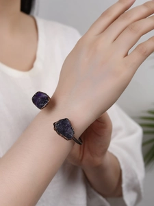 Detail of adjustable bronze bracelet featuring two irregular raw purple amethysts