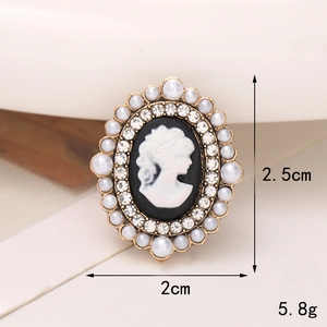 Dettaglio del ciondolo vintage per scarpe con cammeo, perle, strass e cornice dorata